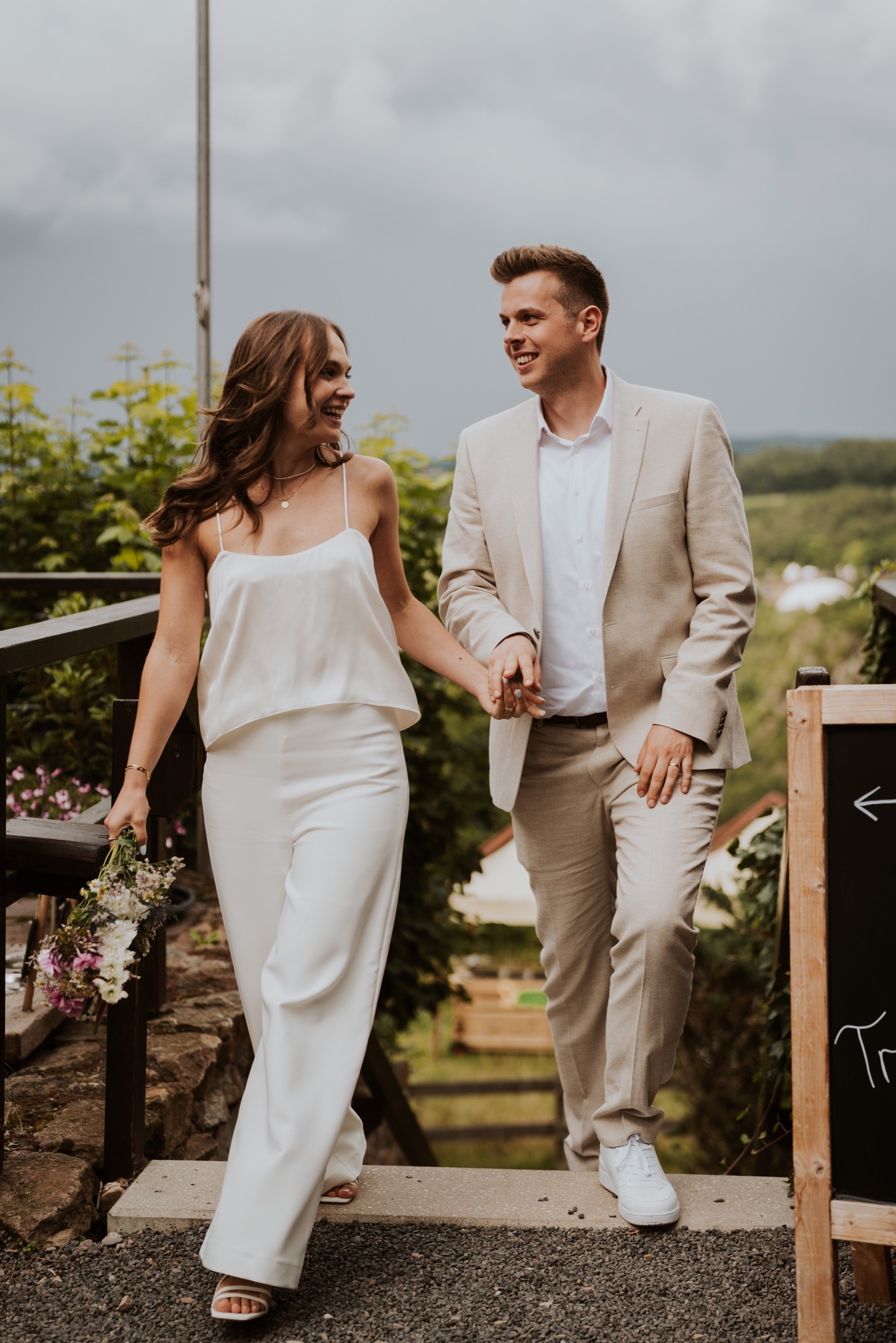 A laughing couple walking down steps hand in hand.