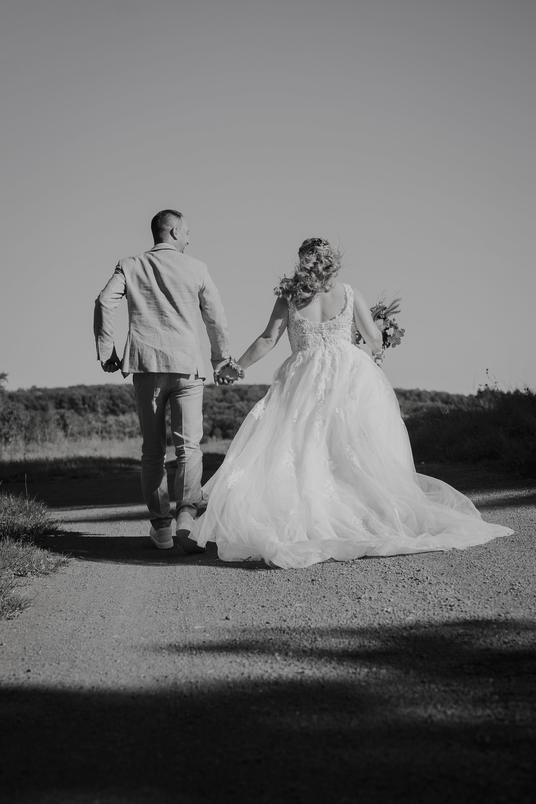 Sarah und Benni laufen Hand in Hand davon, in Schwarz-Weiß.